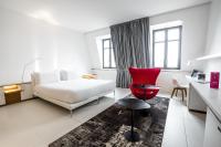 a hotel room with a bed and a red chair at Hotel C2 in Marseille