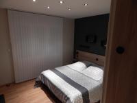 a bedroom with a bed with a black wall at Audionnière in Saint-Gervais en-Belin