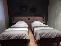 two twin beds in a bedroom with black walls at Audionnière in Saint-Gervais en-Belin
