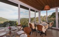 een eetkamer met tafels en stoelen en ramen bij Villa Bella Hotel & SPA Gramado in Gramado