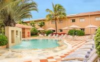 un hotel con una piscina con sillas y palmeras en Gandini Hotel, en Itu