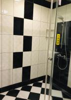 a bathroom with a shower with black and white tiles at 橙橙民宿 in Ruifang