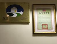 a picture hanging on a wall next to a sign at 橙橙民宿 in Ruifang