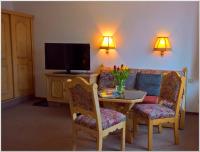 a living room with a table and a couch and a television at Gasthof-Pension Rotes Haus in Kurort Oberwiesenthal