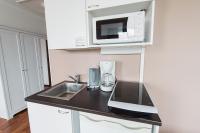 a kitchen with a counter with a sink and a microwave at Forenom Aparthotel Lahti in Lahti