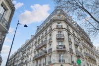 a large white building with balconies on a street at Eiffel Tower view Residence in Paris