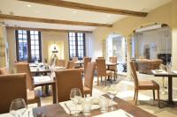 un restaurant avec des tables, des chaises et des fenêtres dans l'établissement LE SOLEIL D'OR, à Joinville