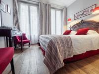 a bedroom with a bed with red pillows and a piano at New Orient Hotel in Paris