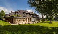 a stone house in a field with a grass yard at Penzion Vejrovna in Přední Výtoň