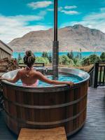 eine Frau in einem Whirlpool mit Bergblick in der Unterkunft Hidden Lodge Queenstown in Queenstown