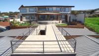 una casa con una escalera que conduce a un patio trasero en Dein Haus Hotel y Departamentos, en Puerto Varas