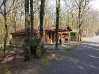 a log cabin in the woods next to a road at Les Chalets Amneville in Amnéville