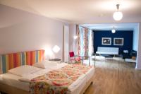 Un dormitorio con una cama y una sala de estar. en das HOTEL in München, en Múnich