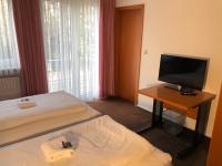 a hotel room with a bed and a television at Hotel Mivano Lehrte in Lehrte
