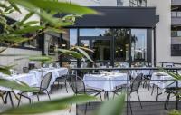 a restaurant with white tables and chairs on a balcony at Ibis Styles Clermont-Ferrand République in Clermont-Ferrand