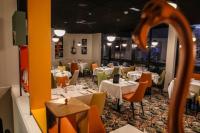 a dining room with white tables and chairs and a room with tables and chairsktop at Ibis Styles Clermont-Ferrand République in Clermont-Ferrand