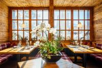 a dining room with two tables with white flowers on it at Hotel-Restaurant Bellevue in Flims