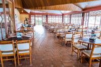 a room full of tables and chairs in a restaurant at Obbá Coema Village Hotel in Capitólio