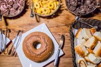 a table with a bagel and a plate of food at Obbá Coema Village Hotel in Capitólio