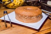 a cake sitting on a white plate with a knife at Obbá Coema Village Hotel in Capitólio