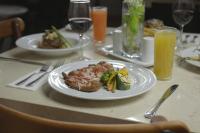 Una mesa con un plato de comida y vasos de jugo de naranja. en Imperio de Angeles Executive León Poliforum, en León