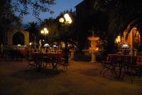 a courtyard with tables and chairs and a fountain at night at Castellu Rossu in Lucciana