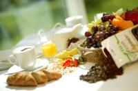 Una mesa con un desayuno de fruta y una taza de café. en Hotel St. Virgil Salzburg, en Salzburgo