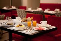 una mesa con comida para el desayuno y bebidas en ella en Hotel Eiffel Seine, en París