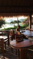 une personne assise à une table dans un restaurant dans l'établissement Lombok Villas, Villa PaoPao, à Labuhanpoh