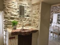 a stone bathroom with a sink and a mirror at Le roc de l&#39;aigle in Cabrespine