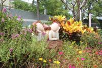 a garden with two statues in the middle of flowers at Yilan Pine Villa Homestay in Luodong