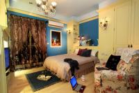 a bedroom with blue walls and a bed and a couch at Happiness B&amp;B in Luodong