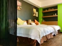 a bedroom with a large bed with green walls at Great Nature Villa in Jiji