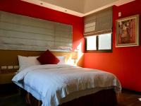 a bedroom with red walls and a bed with white sheets at Great Nature Villa in Jiji