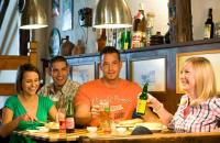 un grupo de personas sentadas en una mesa en un bar en Frühstückshaus Wunderland, en Laa an der Thaya