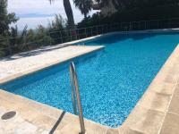 a swimming pool with blue water in a yard at Magnifique Appartement Vue Mer in Vallauris