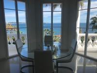 a dining room with a table and chairs and the ocean at Magnifique Appartement Vue Mer in Vallauris