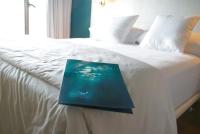 a book sitting on top of a white bed at Hotel Ritual Torremolinos- Adults Only in Torremolinos