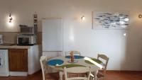 a kitchen with a table and a white refrigerator at Gîte La Fontaine Corse in Loreto-di-Casinca