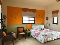 a bedroom with a bed with an orange wall at Remember Sea View B&amp;B in Huxi
