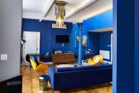 a blue living room with a blue couch and yellow chairs at ABode Manchester in Manchester