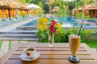 a table with a cup of coffee and a vase of flowers at Island Lodge in Phu Quoc