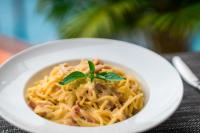een witte kom spaghetti met een basilicumblaadje erop bij Okay 1 Villa in Siem Reap