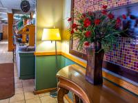 een vaas met rode bloemen op een tafel in een restaurant bij Days Inn by Wyndham Clinton in Clinton