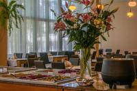 eine Vase mit Blumen auf einem Tisch in einem Zimmer in der Unterkunft Hotel *** NAT Krynica Morska in Krynica Morska