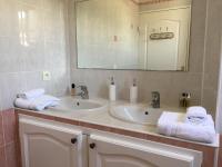 a bathroom with two sinks and a mirror and towels at Jardins du Port Les Issambres - Meublé de Tourisme - Front de mer - Clim in La Garonnette-Plage
