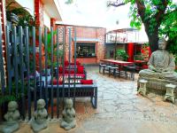 Un patio con una estatua de Buda y sillas. en Fairway Boutique Hotel - Kampala, Uganda, en Kampala