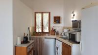 a small kitchen with a sink and a microwave at Gîte La Fontaine Corse in Loreto-di-Casinca