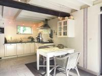 a kitchen with a white table and chairs in it at This accommodation is full of atmosphere and on a beautiful estate in Zedelgem