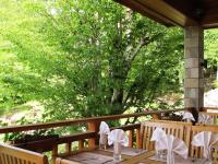a wooden table with white chairs and a tree at Chalet Balkan in Valevtsi